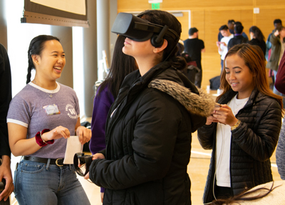 Students try a VR headset during a High School to iSchool event.